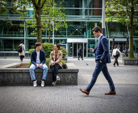 Werkende mensen voor kantoorgebouwen op de Amsterdamse Zuidas, waar de financiële wereld en het dagelijks leven samenkomen.